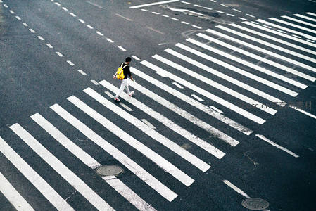 孤独背包客穿越空旷斑马线