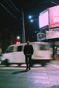 夜色霓虹下，男子伫立斑马线