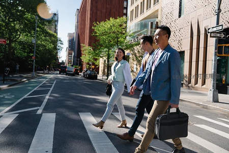 都市白领结伴过街，阳光洒满现代街区
