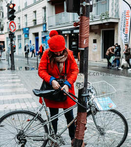 红衣女子锁车街头，冬日暖色点缀寒街