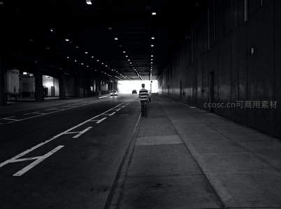 黑白隧道中孤独身影走向光明出口