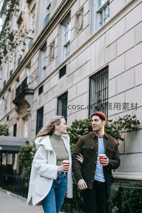 建筑旁情侣牵手喝咖啡闲聊