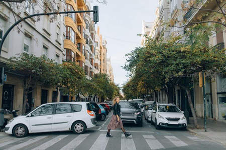 秋日林荫道上优雅穿行的女子