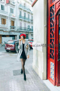 红帽女子街角品尝美食的瞬间