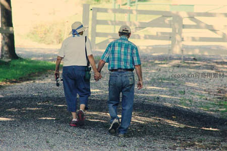 老夫妻牵手漫步乡间小路