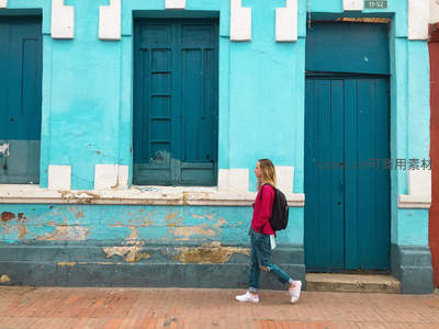 少女走过蓝墙古建筑街道
