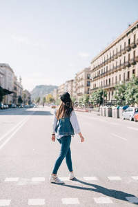 阳光下女孩独自走在城市大道