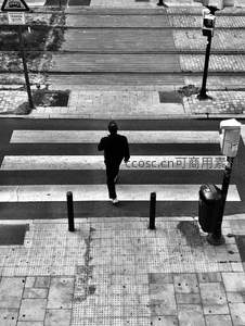黑白街景中独行者穿越斑马线