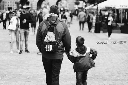 父子携手穿行市集广场