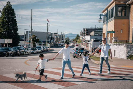 一家四口牵狗过马路享受阳光周末