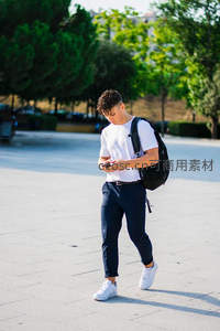 年轻男子户外行走专注看手机屏幕