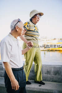 夕阳下携手散步的老年伴侣