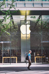 苹果门店前漫步，绿叶掩映下的科技时尚地标