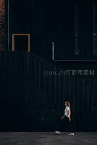 极简黑墙前独行少女身影