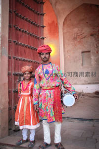 印度父子身着彩衣，门前微笑合影