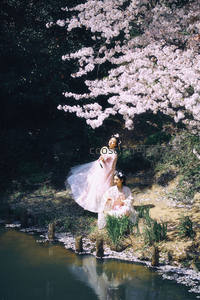 樱花树下两位古装女子赏花临水