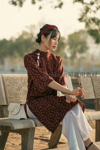 女子静坐长椅，旗袍映衬秋日暖阳温柔时光