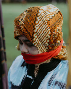 头戴传统蜡染头巾的女子闭目沉思，神情宁静