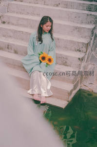 青衣少女持向日葵静坐石阶水边