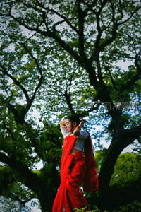 红裙女子树下舞动，绿荫环绕如诗