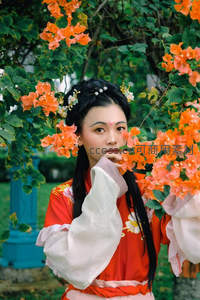 红衣古风少女倚花丛凝望