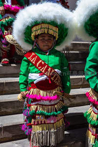 绿衣童子戴白羽帽参加传统庆典游行