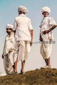 三位白袍男子立于土丘之上