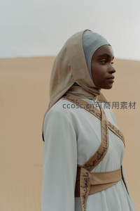 沙漠侧影回眸凝望，头巾文字诉故事
