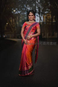 暮色中纱丽女子漫步林荫小径