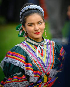 身着绚丽民族服饰的年轻女子微笑凝视