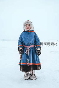 雪地中穿着蓝色传统冬装的孩童