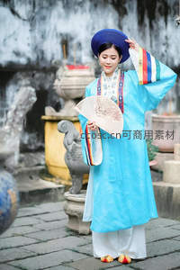 蓝衣女子庭院持扇优雅微笑