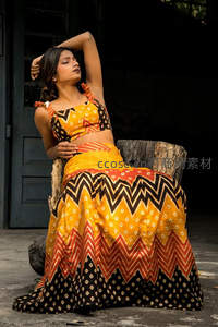 身着黄黑几何纹服饰的女子优雅倚坐