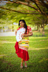 绿茵树影下身着非洲传统服饰的优雅女性