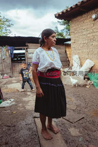 乡村庭院中赤脚站立的妇女身影