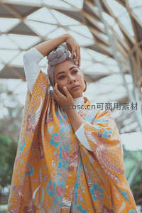 现代建筑下身披彩纱的时尚女子