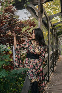 秋日庭院花裙女子轻触红叶