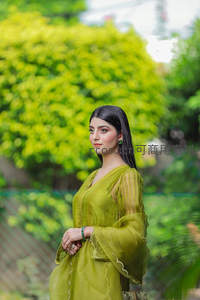 绿衣女子花园中侧颜回眸微笑