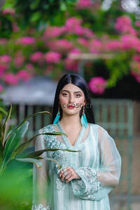 浅蓝刺绣长裙女子花丛前静立