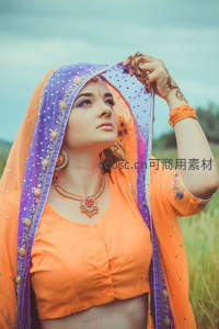 橙紫纱丽女子田野间抬眸望天尽显异域风情