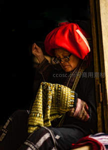 老妇窗边专注织布刺绣