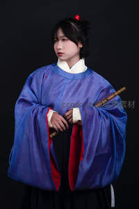 蓝袍少女手持竹笛凝望远方