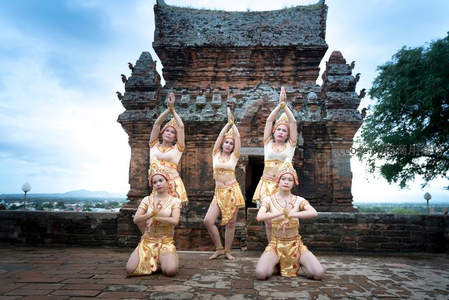 四位舞者古塔前表演传统舞蹈
