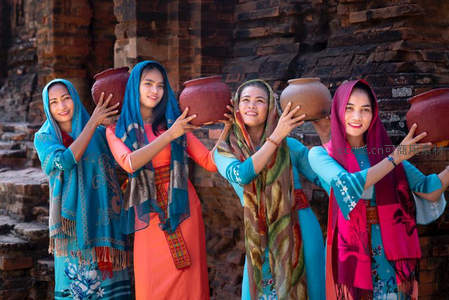 四位女子头顶陶罐展笑颜