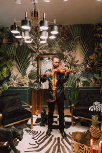 热带风情室内演奏小提琴的男子