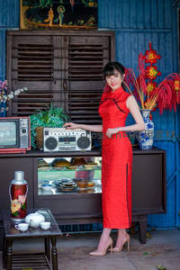 红旗袍佳人立怀旧家电旁