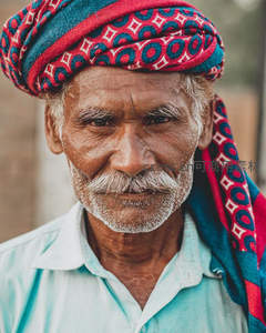 沧桑老人头戴彩纹头巾微笑