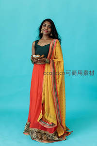 身着传统服饰的女子手持祭品