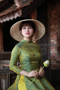 戴斗笠女子持莲花古宅门前
