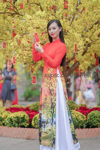 黄花树下持红包，红白长裙映春光